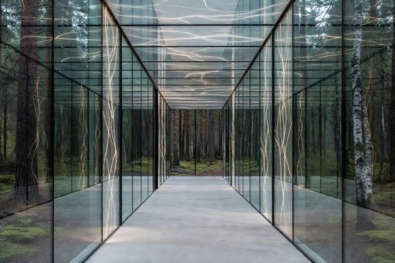 Minimalist glass corridor inside a remote woodland architectural retreat